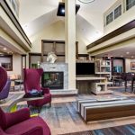 Modern hotel lobby with comfortable seating, fireplace, and lounge area.