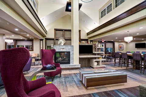 Modern hotel lobby with comfortable seating, fireplace, and lounge area.