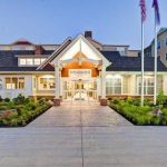 Grand, modern two-story home with a large front walkway and manicured landscaping.