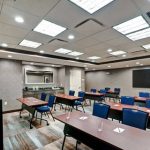 Modern conference room with a large table, chairs, and bright ceiling lighting.
