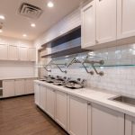 Modern kitchen with white cabinetry, subway tile backsplash, and stainless steel sink.