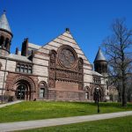 Gothic revival university building with towers under a clear blue sky.