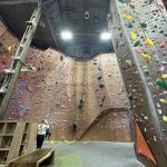 Indoor rock climbing gym with large, colorful artificial walls and climbing holds.