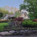 Suburban house with mature trees and landscaped garden in a residential setting.