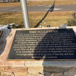 Bronze plaque detailing the meaning of a sculpture related to 9/11 and its enduring consequences.