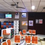 Arcade room with video games, seating area, and overhead lighting.