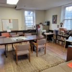 Cozy library or study room with wooden tables, comfortable seating, and bookshelves.