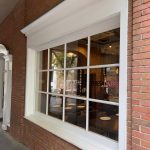Large storefront window showcasing a cafe interior with brick exterior.
