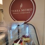 Display case filled with small, layered desserts in front of a Terra Momo Bread Company logo.