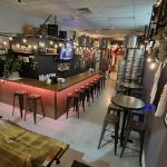 Retail shop interior with rustic wooden tables, merchandise displays, and industrial metal shelving.