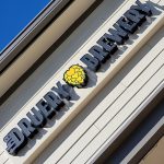 "Druery Brewery" sign with a yellow flower logo on a modern building facade.