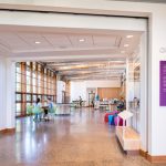 Modern, bright lobby with glass walls leading to an open, industrial-style interior space.