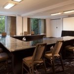 Conference room with large dark table, chairs, and a projection screen.