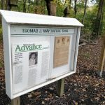 Trail sign for Thomas J. May Nature Trail detailing toxic waste dump history.