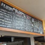 Menu board displaying ice cream and blended drink prices at a shop.