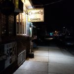 Nighttime view of a pub exterior with Guinness signage and sidewalk.
