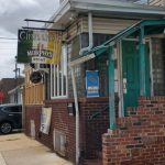 Corner storefront with "Murphy's" sign, brick facade, and residential building above.