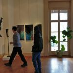 Man viewing abstract art in a bright, modern gallery space.