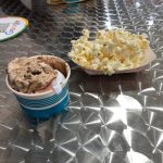 Sweet treats and popcorn on a reflective metal table surface.
