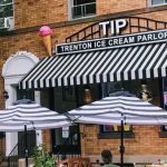Trenton Ice Cream Parlor storefront with striped awning and outdoor umbrellas.