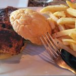Grilled chicken and a bun served with a generous side of golden french fries.