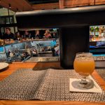 Orange juice and dining setting with a bar area visible in the background.