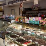Bakery display case filled with various pastries, cookies, and sweets in a shop setting.