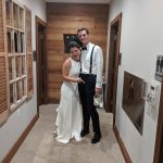 Couple dressed up standing in a modern hallway with wood paneling.
