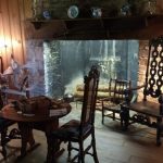 Rustic interior with a stone waterfall feature, wooden furniture, and warm lighting.