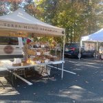 Outdoor market stall displaying baked goods from Terra Momo Bread Co. under a white tent.
