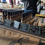 Spicy hot sauce tasting booth at a market, featuring various labeled bottles.