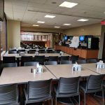 Large, modern cafeteria or common area with tables and chairs.