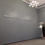 Hallway with "HILLMAN PERFORMANCE HALL" signage and modern lighting fixtures.