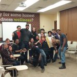 Group of diverse people gathered in a modern conference room for a wellness event.