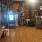 Rustic interior of a winery featuring wooden walls, wine displays, and decorative elements.
