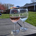 Two wine glasses with "Working Dog" logos on a dark outdoor table.