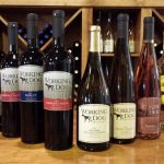 Row of various bottles of Working Dog Winery wine displayed on a wooden shelf.