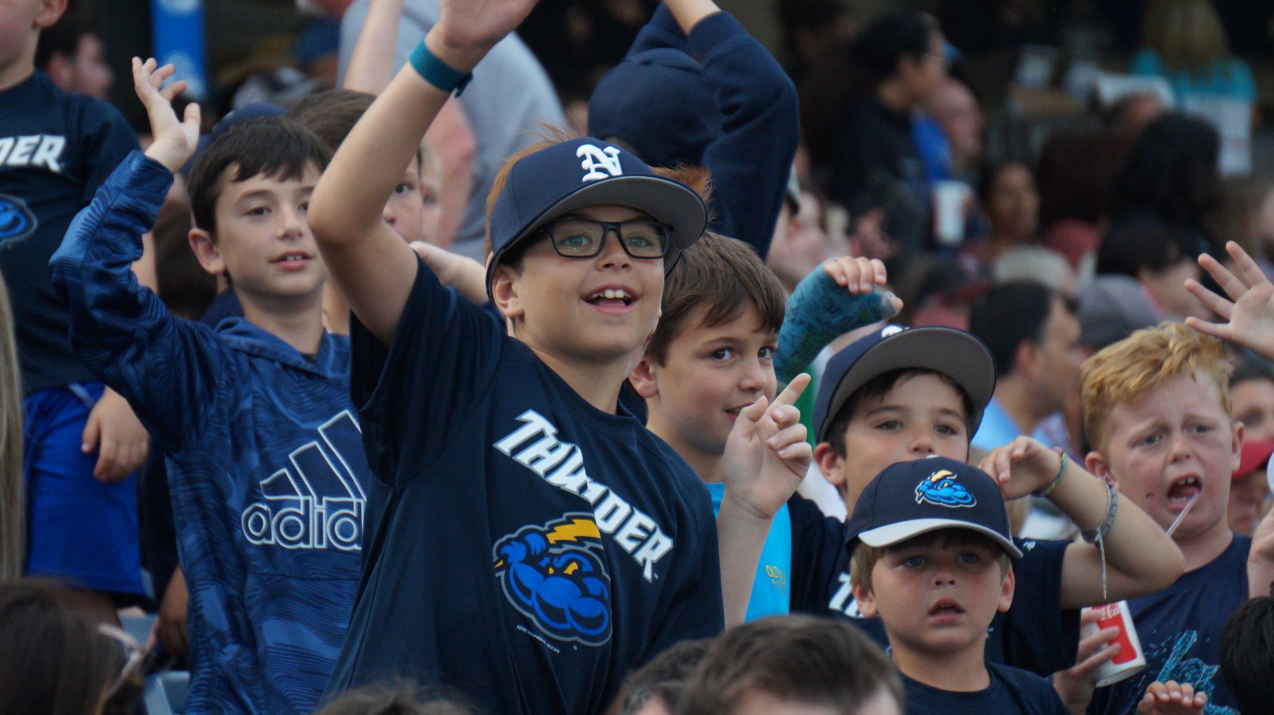 kids cheering at a baseball game in the stands