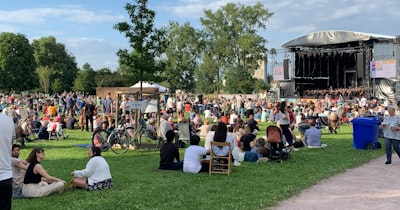 A concert crowd seating on the grass at an open air classical music concert